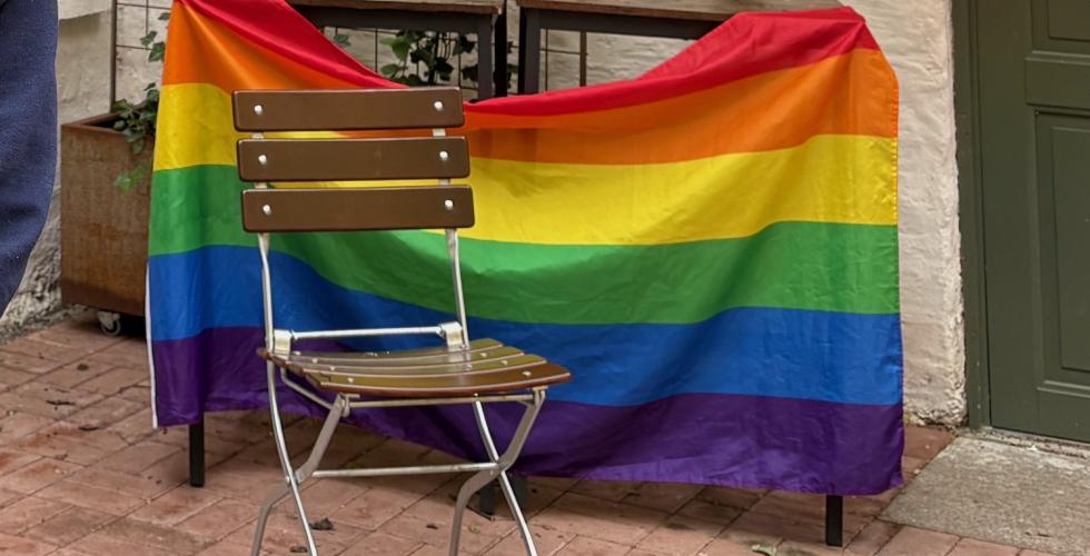 et prideflagg med en stol foran
