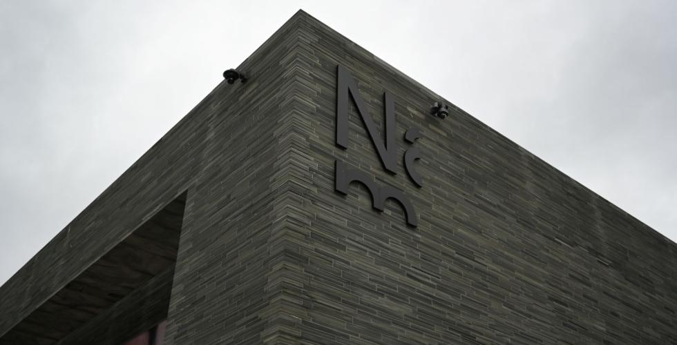 Foto av utsiden av Nasjonalmuseet foran en gr&aring; himmel