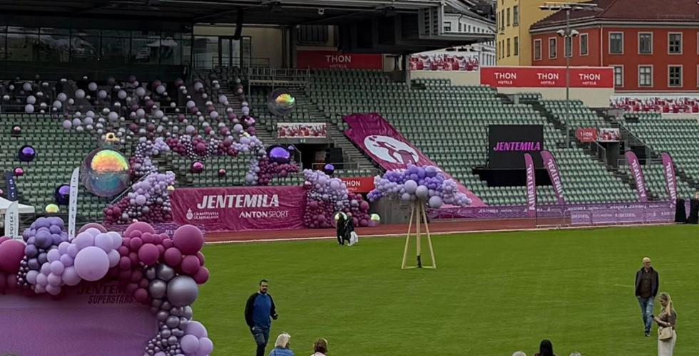 Oversiktsbilde av Bislett stadion pyntet med lilla og rosa ballonger, stands og Jentemila-bannere. 