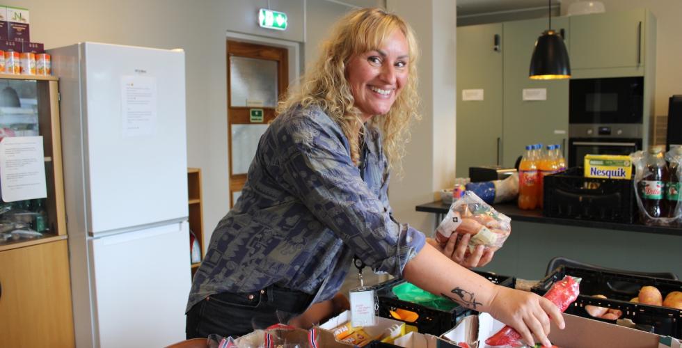 Kvinne som pakker ut mat på kjøkken