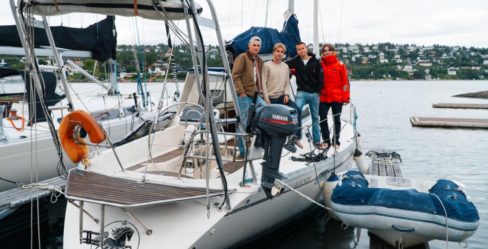 Fire gutter st&aring;r p&aring; siden av seilb&aring;ten "sleipner"