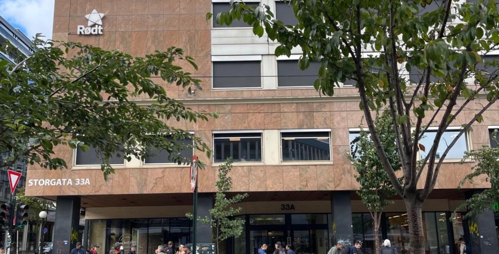 Flere personer st&aring;r p&aring; fortauet utenfor Storgata 33A i Oslo.