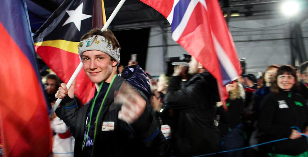 Birk Ruud smiler og holder det norske flagget, i bakgrunnen er det fult av mennesker. Foto: Caroline Dokken Wendelborg/ NIF, CC flickr 