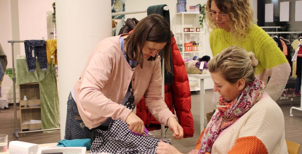 Medlemmer fra RELOVE og daglig leder for bruktbutikk på Holmlia ler og koser seg mens de arbeider