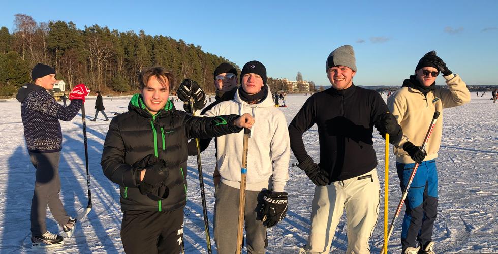 Gruppebilde av folk som spiller ishockey på fjordisen