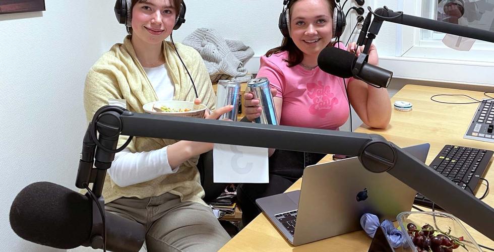 to smilende jenter i studio med mikrofoner
