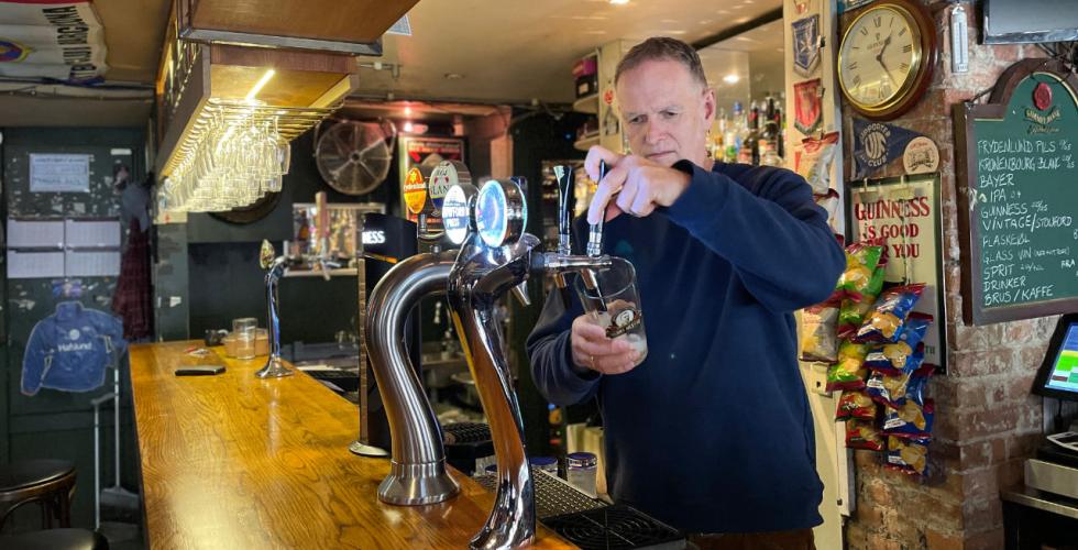 Leder i Bohemen sportsbar står ved tappekranen i baren  