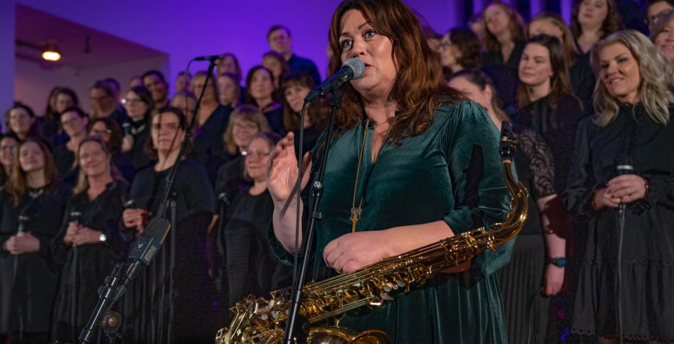 Saxofonist Frøydis Grorud står foran koret Gospel explosion