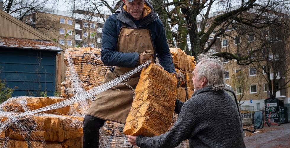 Robert Mhyrer (56) leverer ved til Arvid Nilsen (67) fra toppen av en lastebil