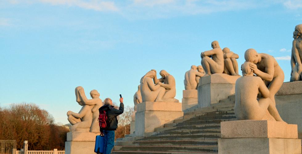 Bilde av en mann som ser på skulpturene i Vigelandsparken