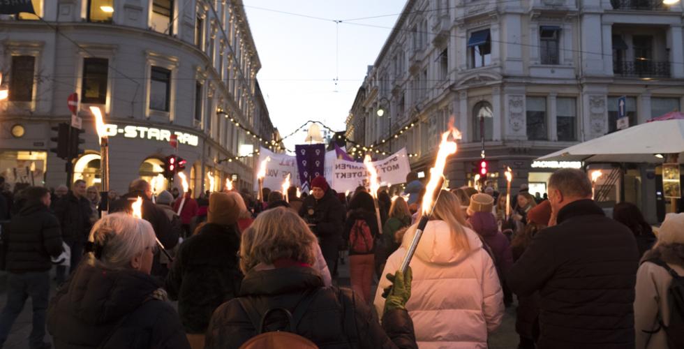 En mengde folk som går i fakkeltog foran Stortinget