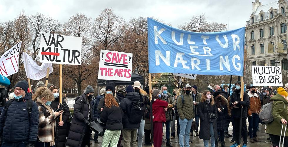 Mennesker som står med bannere på Eidsvolds plass