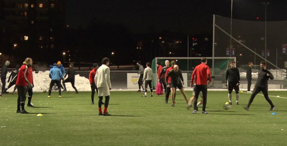 Flere menn løper rundt på en fotballbane. 