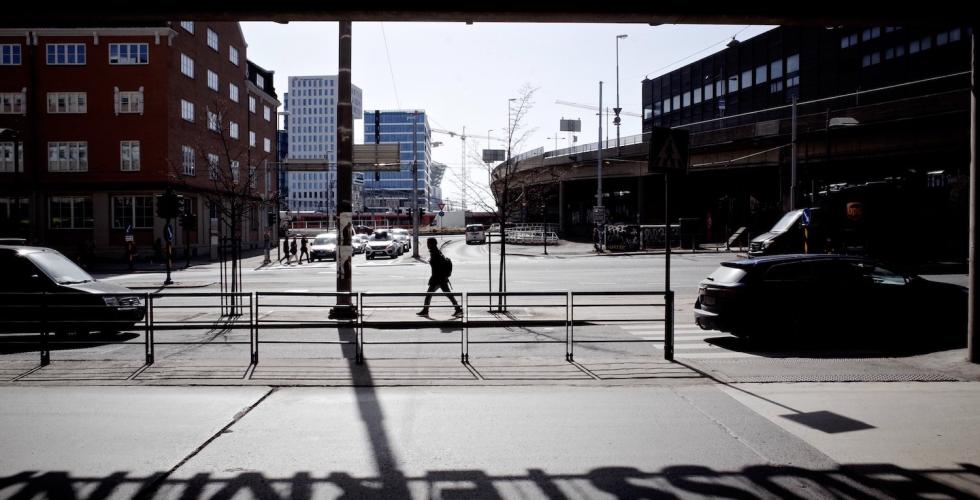 En mørkt kledd mann går langs en vei utenfor Bussterminalen i Oslo. 