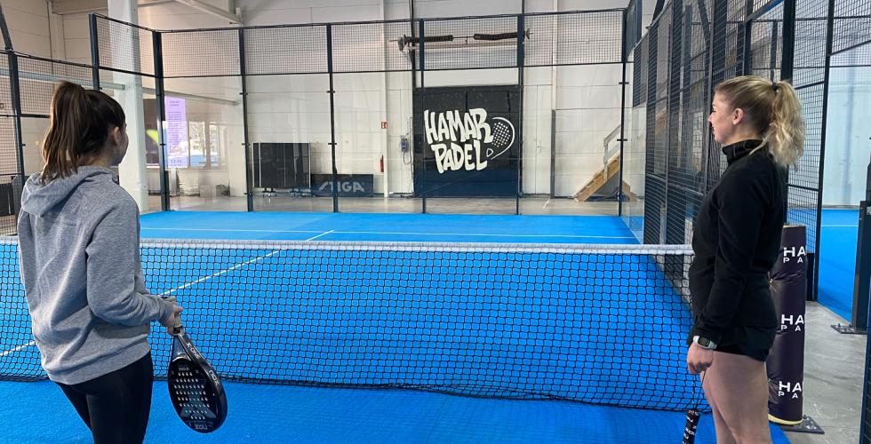 Bilde inne på Hamar Padel. To jenter er ute på banen. 