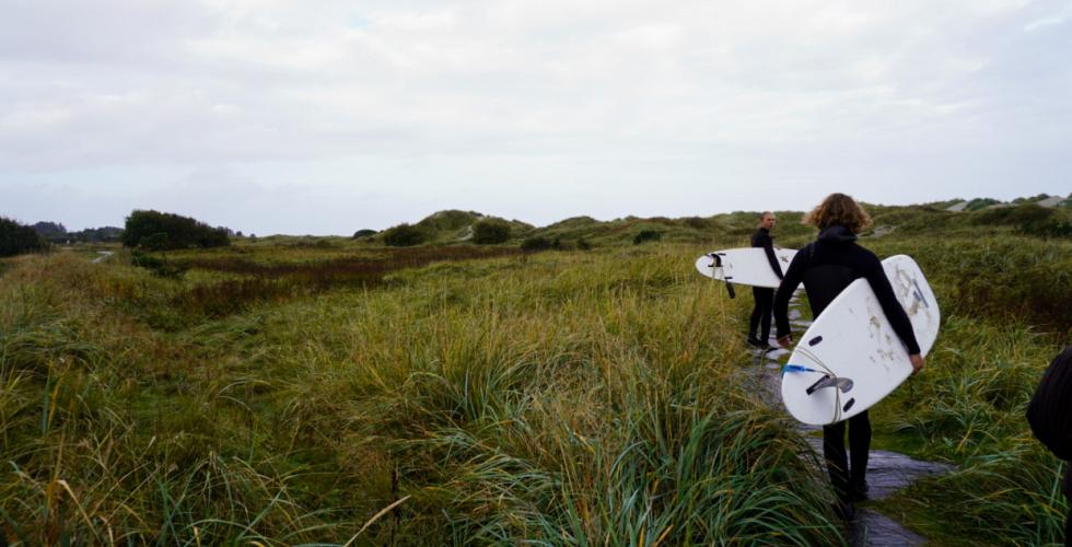 Mikael (20) og Lars (22) er på vei til stranden med surfebrettene sine.