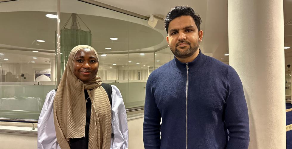 Latifa Agouda og Abdul Wahab smiler til kamera i moskeen.