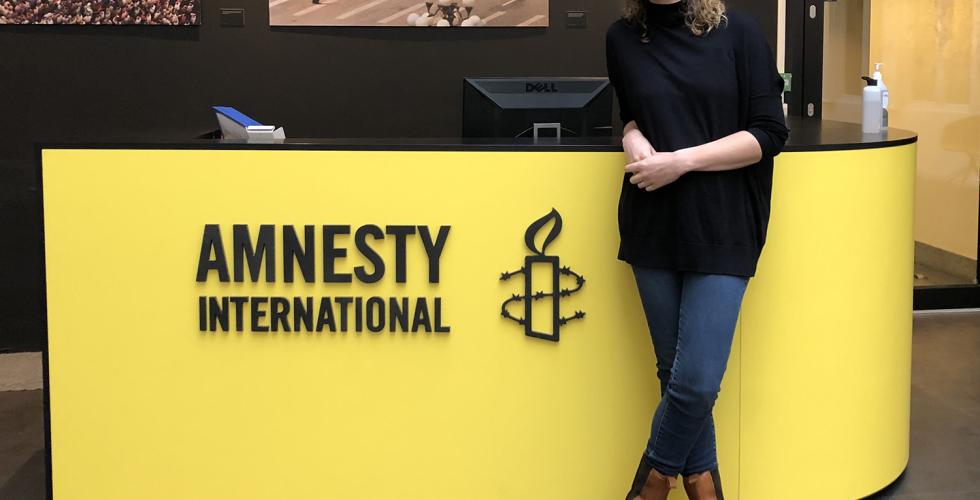 Ingrid Westgaard Stolpestad stående foran inngangen til kontoret hos Amnesty.