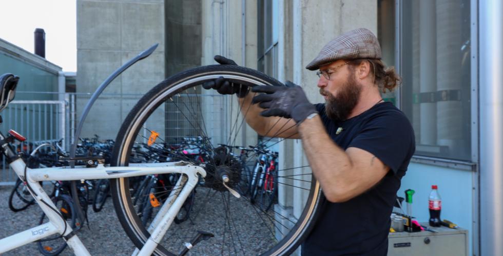 Ivar Örn Sverrisson, en islending med skjegg, fikser på en sykkel.