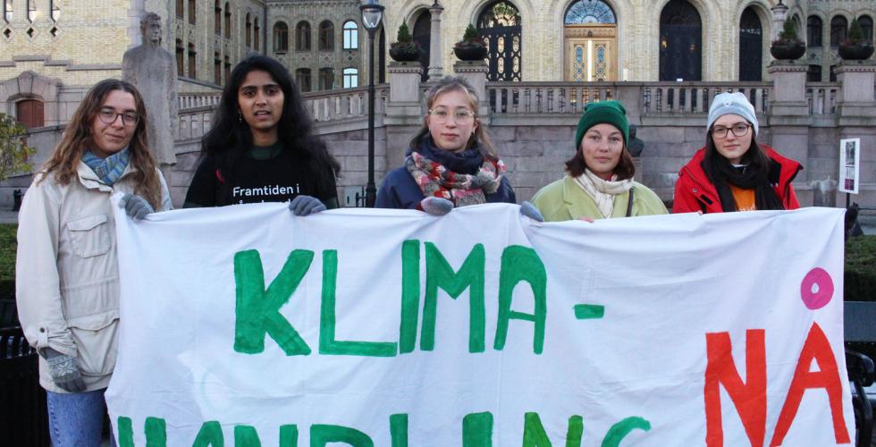 Unge som holder en plakat foran Stortinget