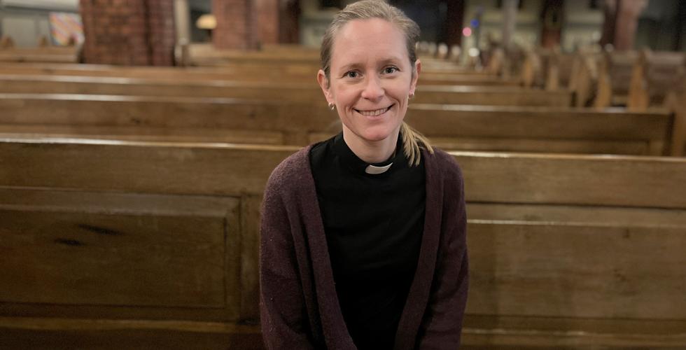 Krisitn Heskje, prest i Uranienborg kirke sitter smilende i kirkebenken i Uranienborg kirke.