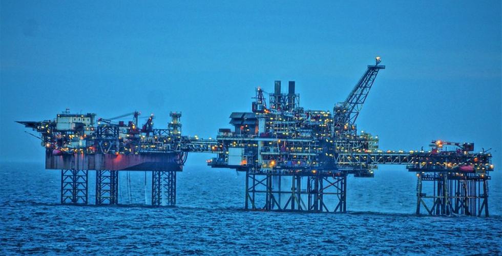 Oljeplatform ute på havet. Masse lys på oljeplatformen.