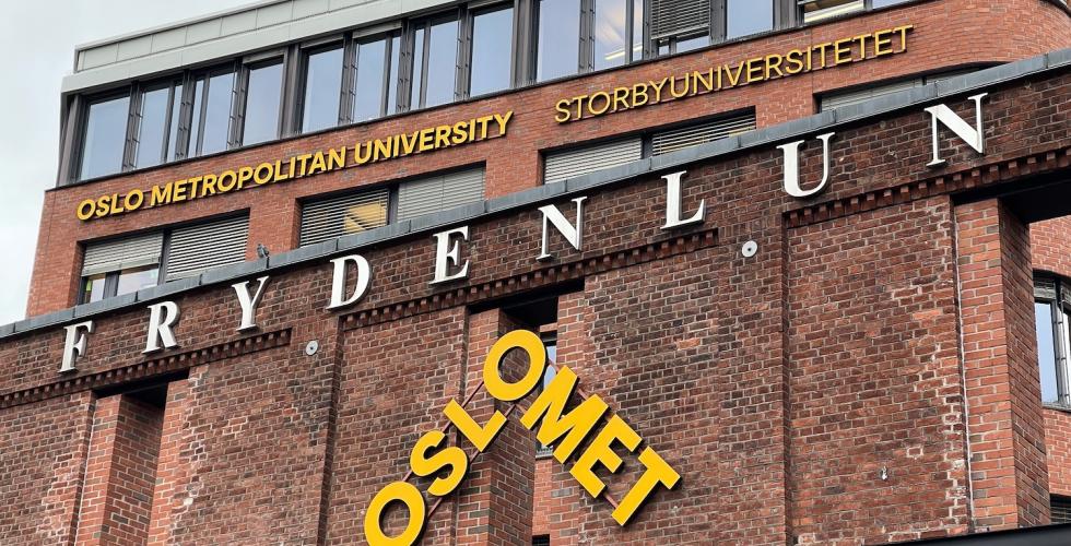 Bilde av OsloMet-skilt over hovedinngangen til universitetet. 