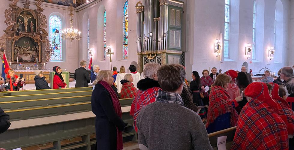 folk ser på et følge som går inn midtgangen i Oslo domkirke