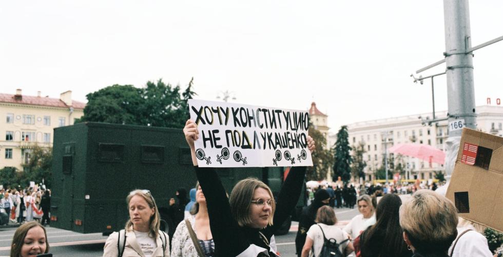 En hviterussisk jente holder en plakat med tekst på russisk under demonstrasjonene høsten 2020. På plakaten står det "Jeg vil ha grunnloven, ikke under Lukashenko"