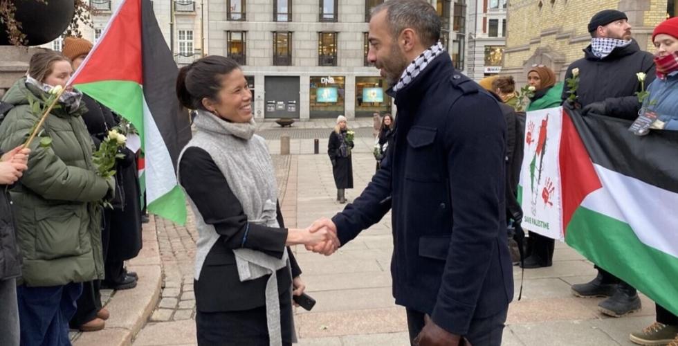 Aksjonist Rami Samandar håndhilser med politiker Lan Marie Berg utenfor Stortinget