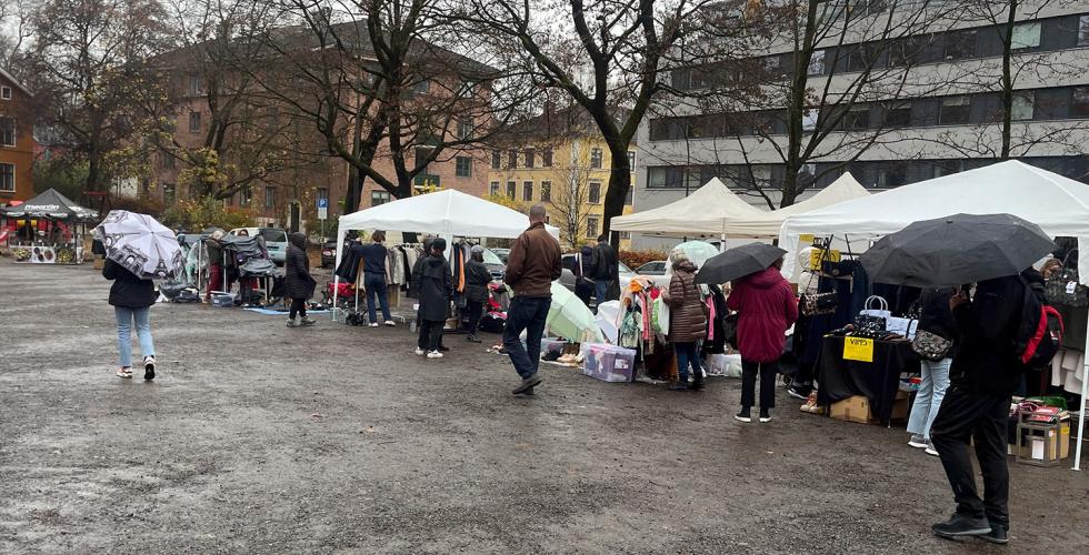 Bildet viser Vestkanttorget og besøkende og det regner