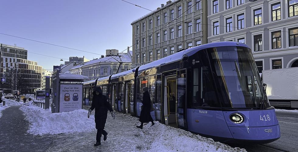 Trikk i snø med sol på himmelen