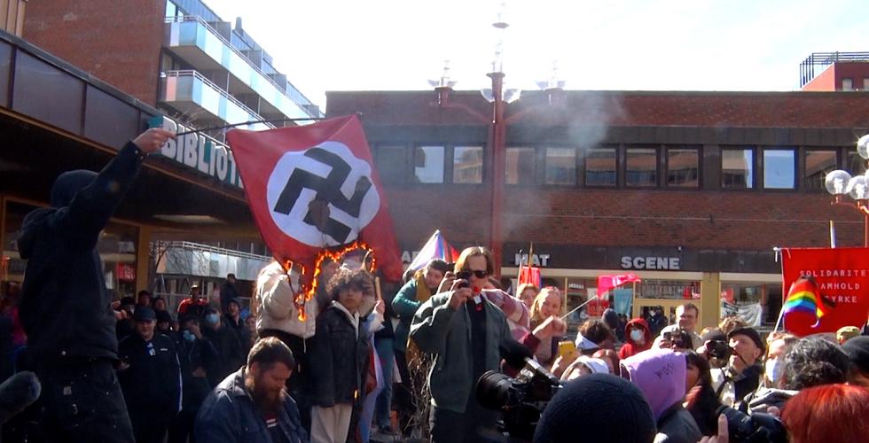 En gruppe motdemonstranter brenner et naziflagg på Tøyen torg i Oslo. 