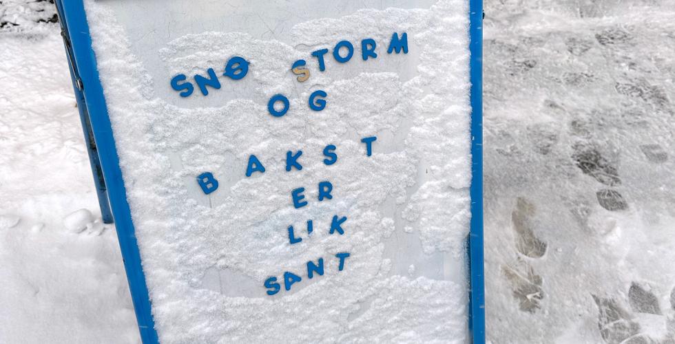 Et skilt utenfor en kafe der det står at snøstorm og bakst erlik sant