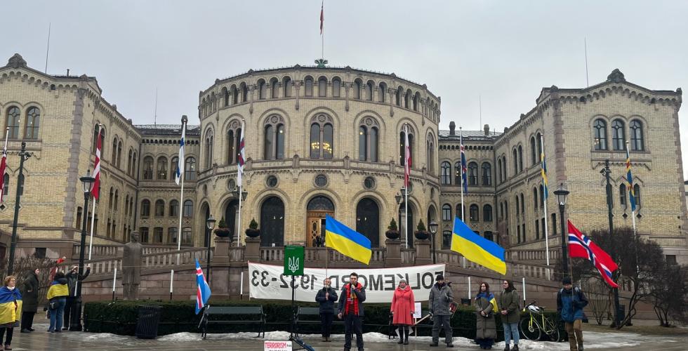 Bildet foran Stortinget med to Ukrainske flagg i forgrunn.