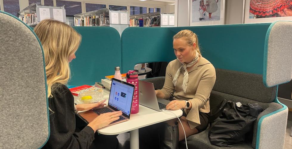 to jenter som sitter og studerer på biblioteket på OsloMet.