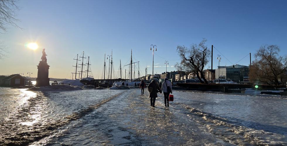 Mennesker som går på isglatt føre i by