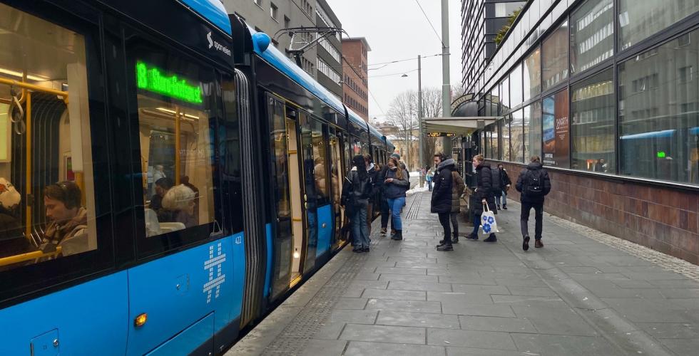 Bilde av et trikkestopp hvor mennersker går inn på trikken.