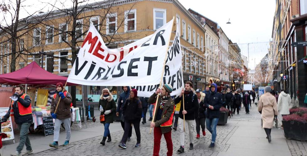 Vaksinemotstanderne fra gruppen, Røde luer, marsjerer gjennom Oslo med stort banner hvor det står: "media er viruset".