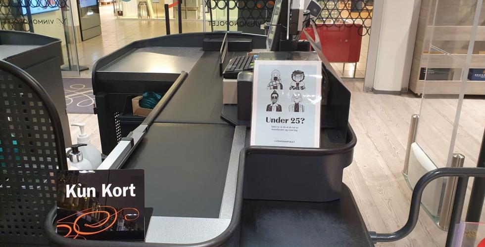 Vinmonopolet vil at kunder under 25 år skal vise legitimasjon og ta av munnbindet. 