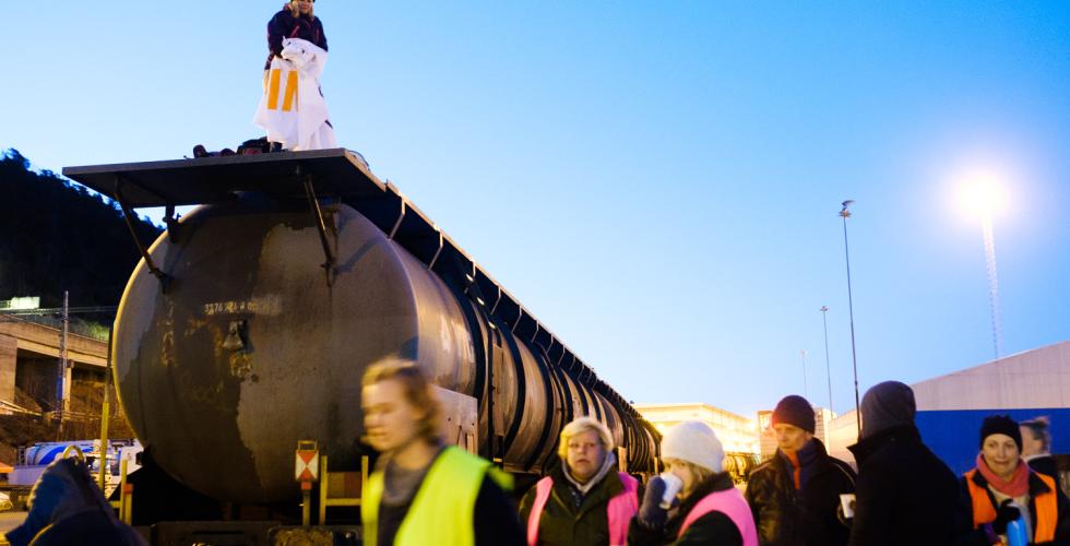 Aksjonister fra Extinction Rebellion myldrer rundt et tog de blokkerer en tidlig morgen i Oslo Havn.