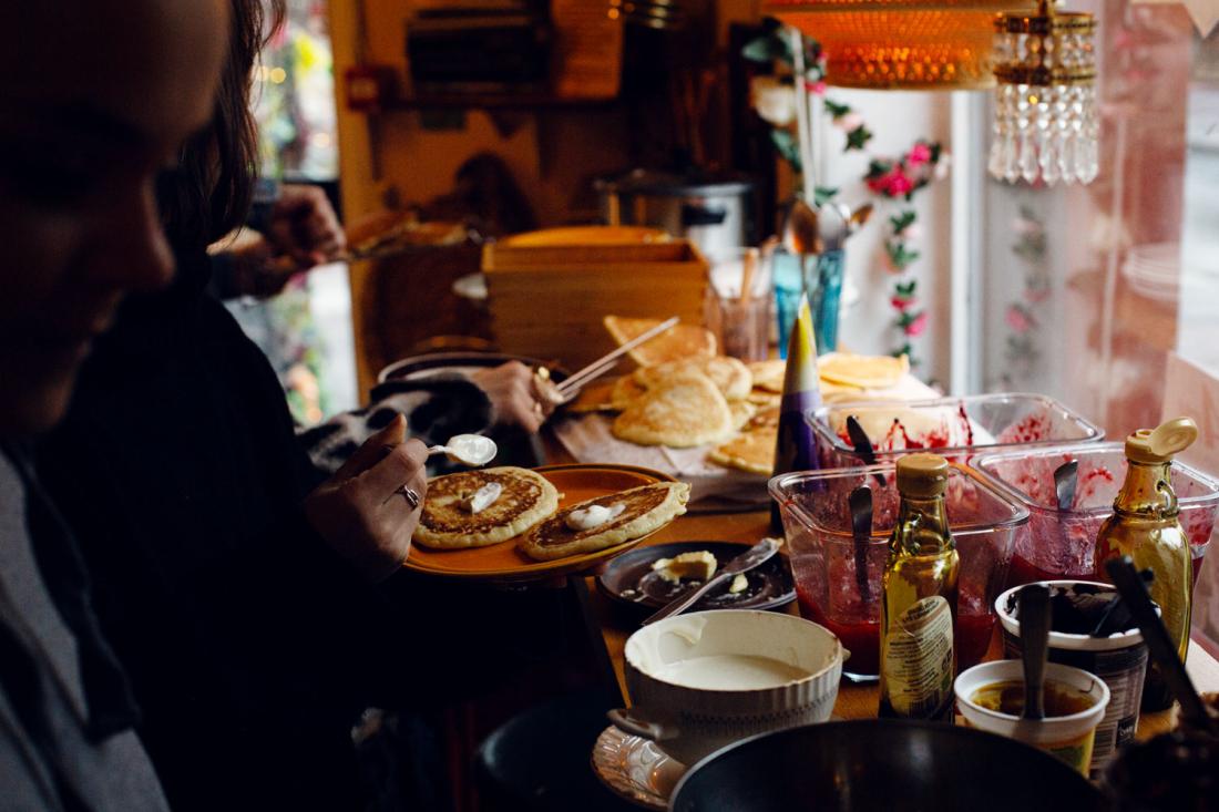 Gjester forsyner seg av pannekakebuffet på kafé