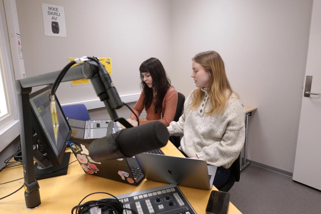 To personer foran datamaskiner i lydstudio