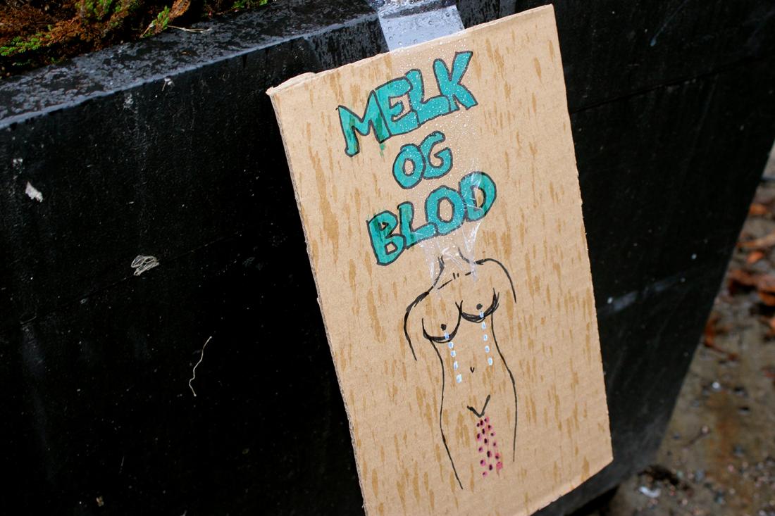 Plakat der det st&aring;r Melk og blod med en tegning av en kvinnekropp