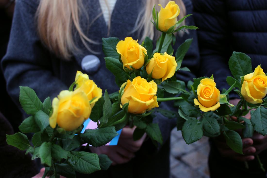 Gule roser i hendene p&aring; tre ungdommer