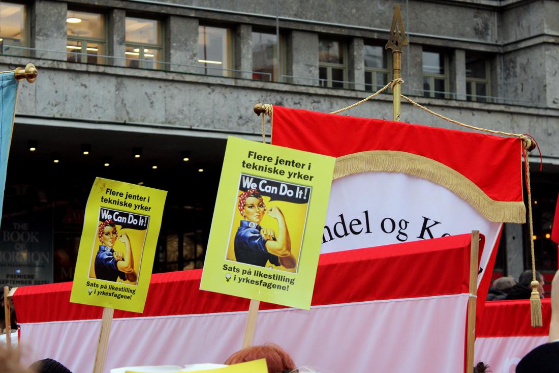 Flere hender holder opp plakater der det st&aring;r "Flere jenter i tekniske yrker, sats p&aring; jenter i yrkesfag" med et bilde av Rosie the Riveter og "we can do it"-slagordet hennes