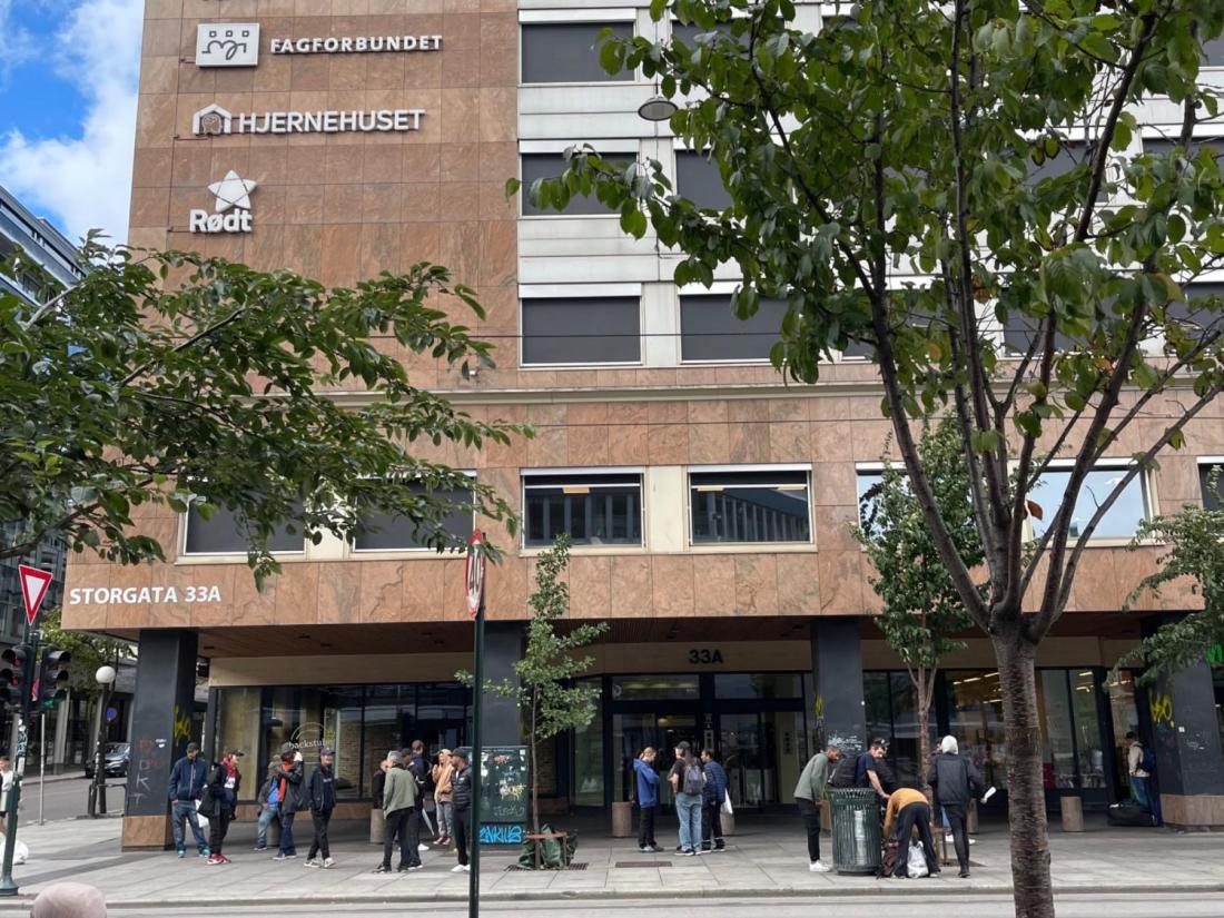 Flere personer st&aring;r p&aring; fortauet utenfor Storgata 33A i Oslo.